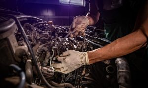 Close up of mechanic arms /hands working on car engine